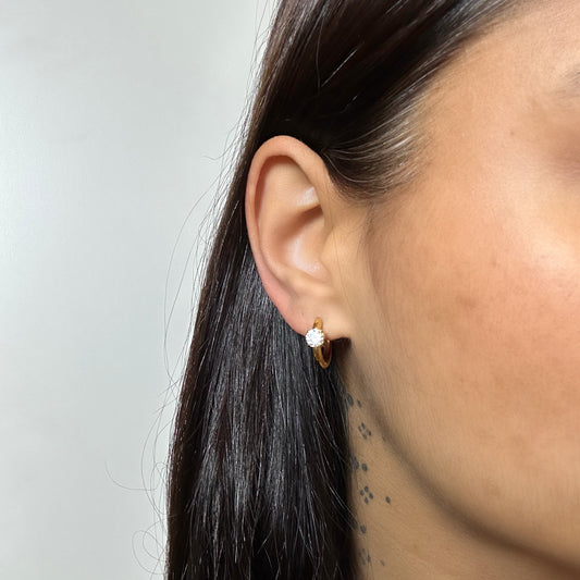 Boucles d’oreilles Théa dorées en acier inoxydable portées – créoles délicates avec strass scintillant – Monalya