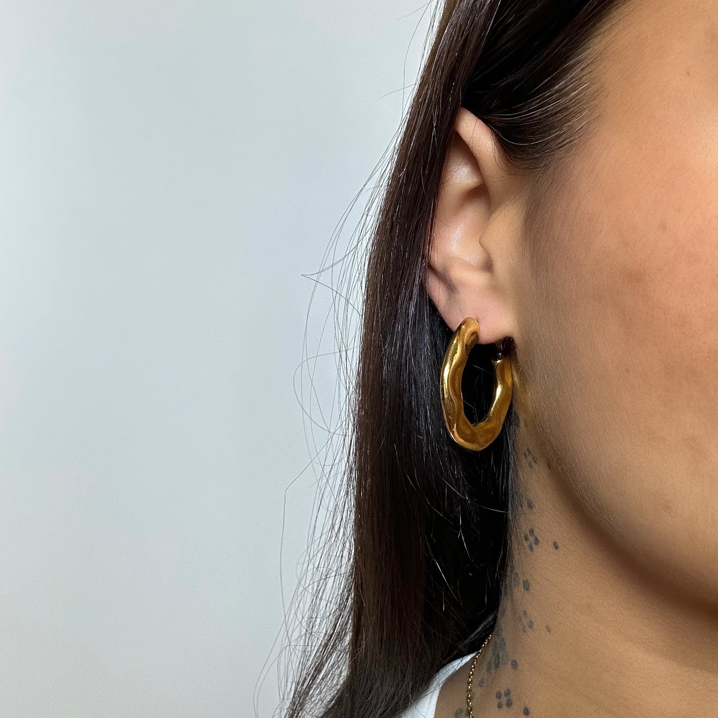 Boucles d’oreilles Sana dorées portées en acier inoxydable - créoles irrégulières effet martelé