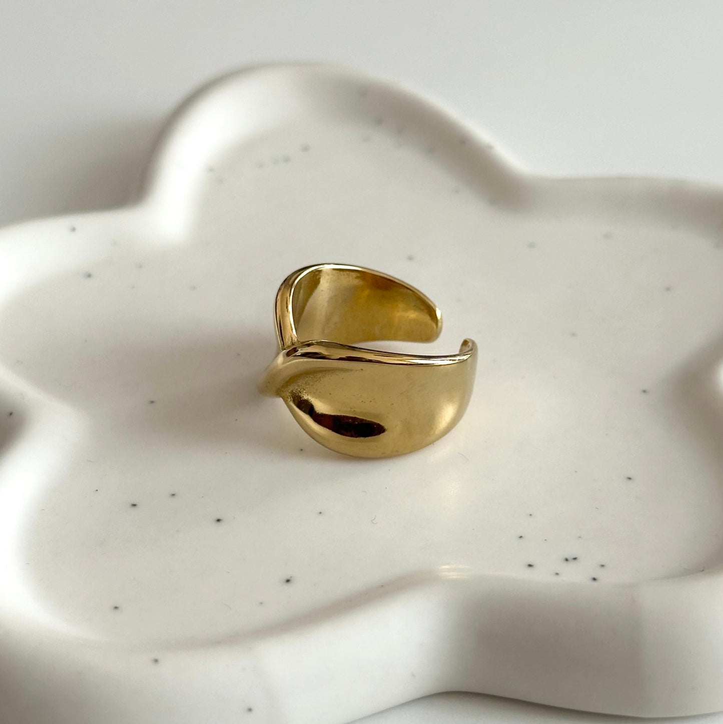 Vue de côté de la bague Charlie dorée ajustable avec finition lisse et design bombé.