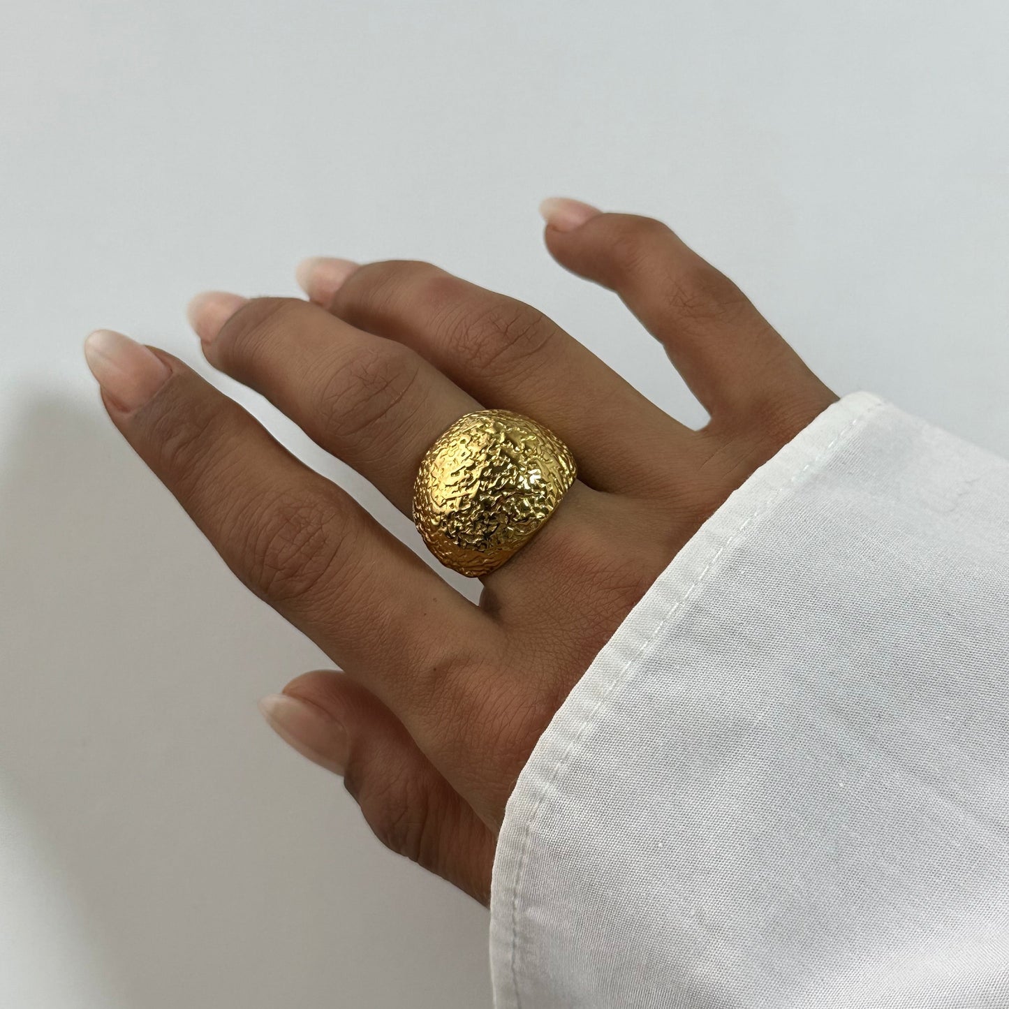 Bague Cléa dorée en acier inoxydable portée au doigt – bague martelée texturée, style organique brut – bijou résistant à l’eau – Monalya