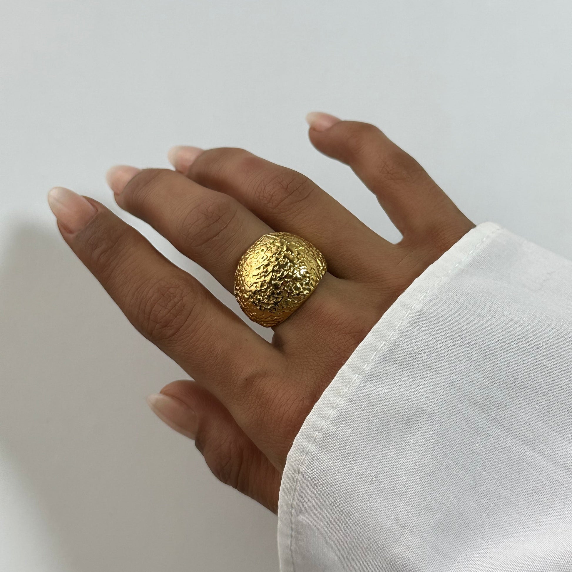 Bague Cléa dorée en acier inoxydable portée au doigt – bague martelée texturée, style organique brut – bijou résistant à l’eau – Monalya