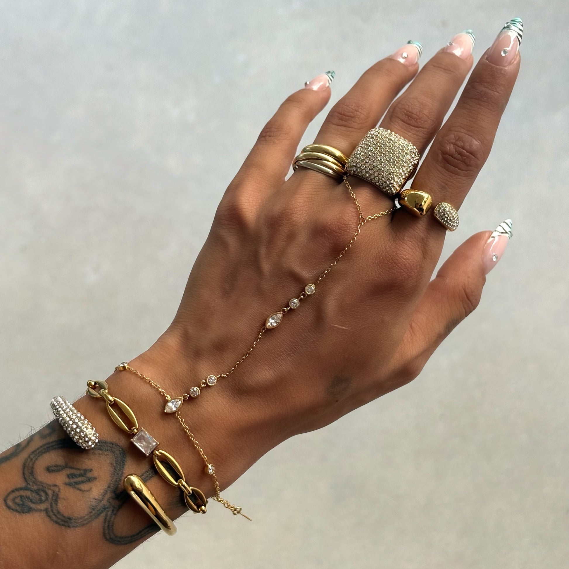 Bague Erin en acier inoxydable 304 et strass portée avec une accumulation de bagues dorées