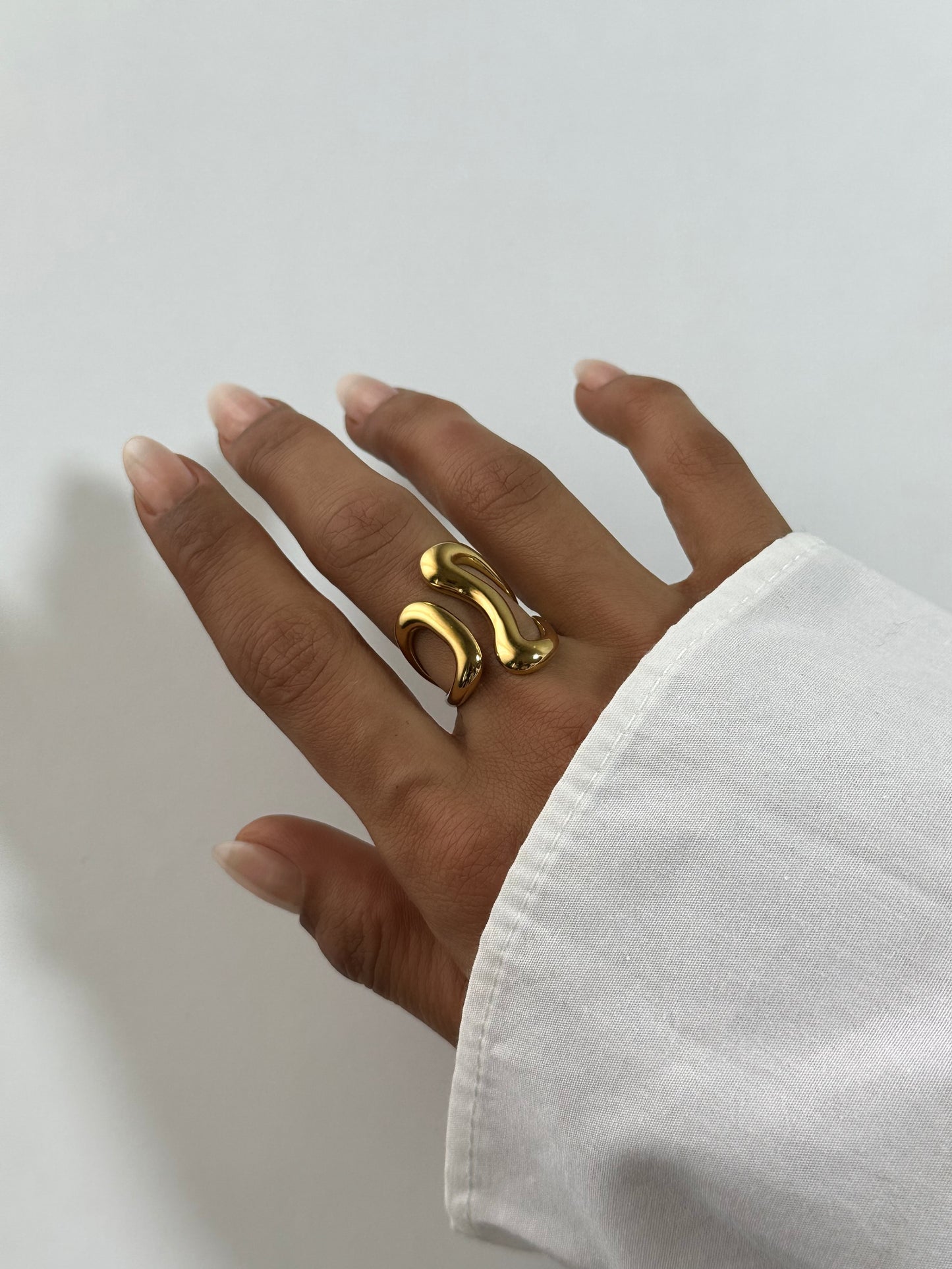 Bague Liv dorée en acier inoxydable portée au doigt – bague ondulée minimaliste, style fluide et moderne – bijou résistant à l’eau – Monalya