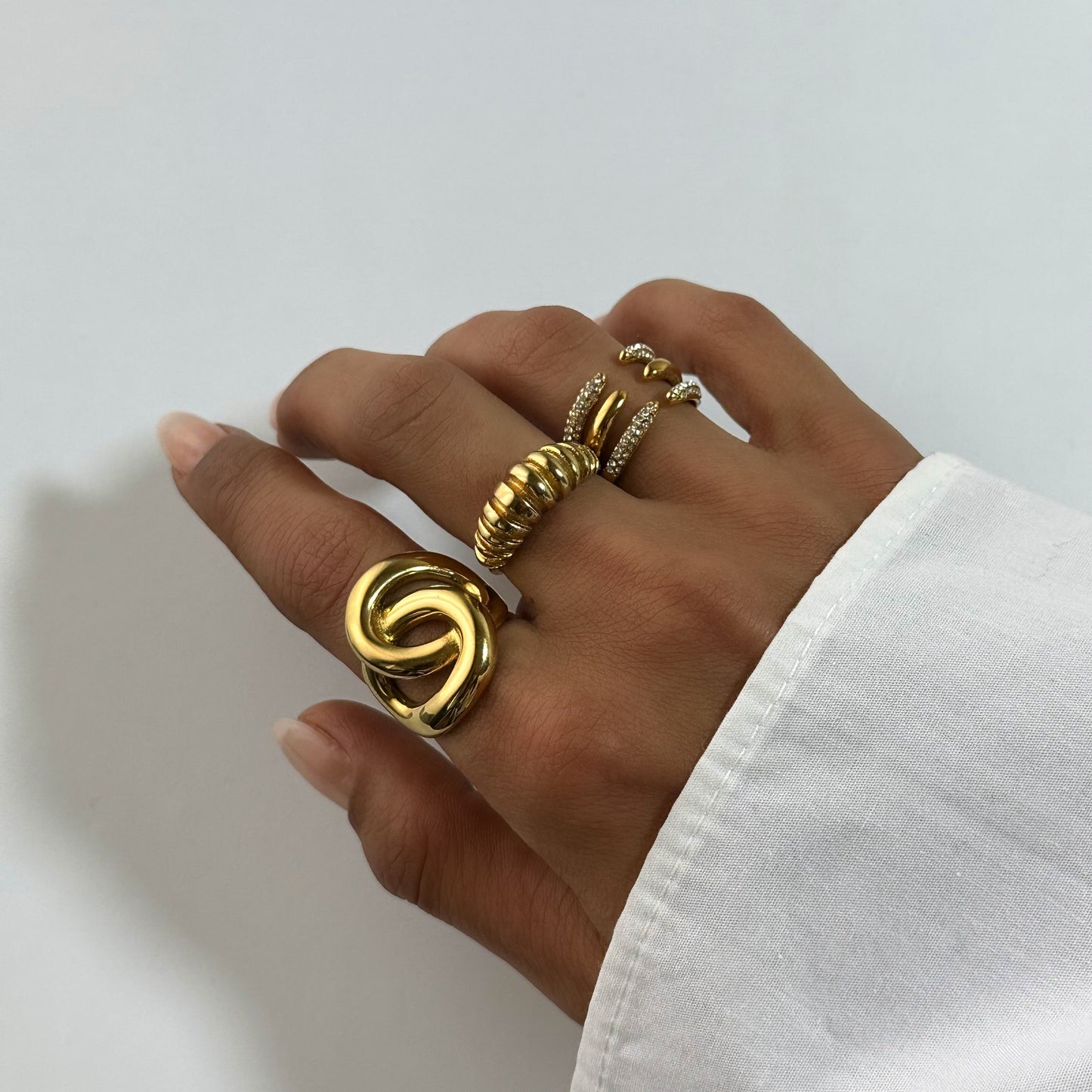 Bague Sélia dorée en acier inoxydable portée avec d’autres bagues dorées – bague ouverte pavée de zircons – bijou moderne et résistant à l’eau – Monalya