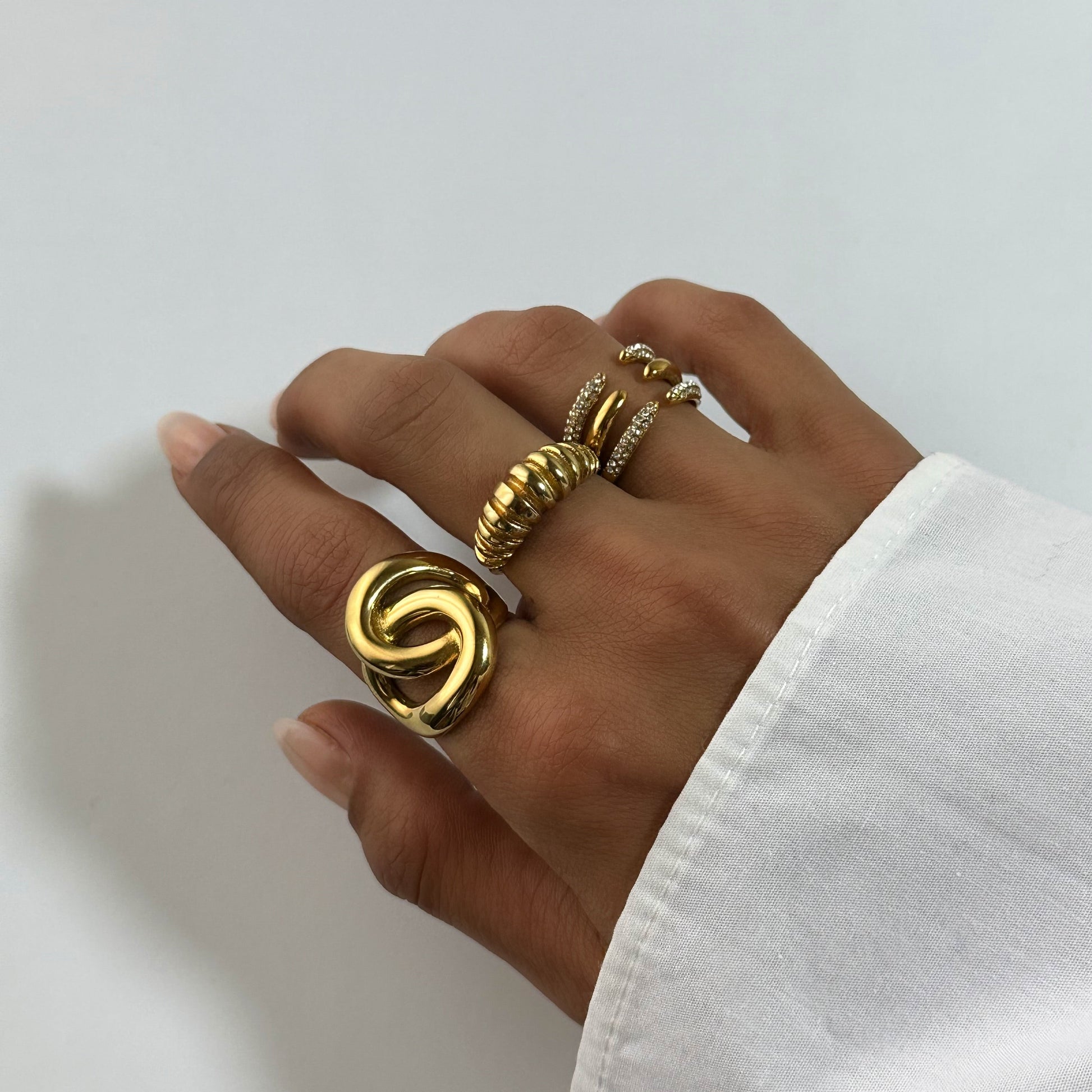 Bague Sélia dorée en acier inoxydable portée avec d’autres bagues dorées – bague ouverte pavée de zircons – bijou moderne et résistant à l’eau – Monalya