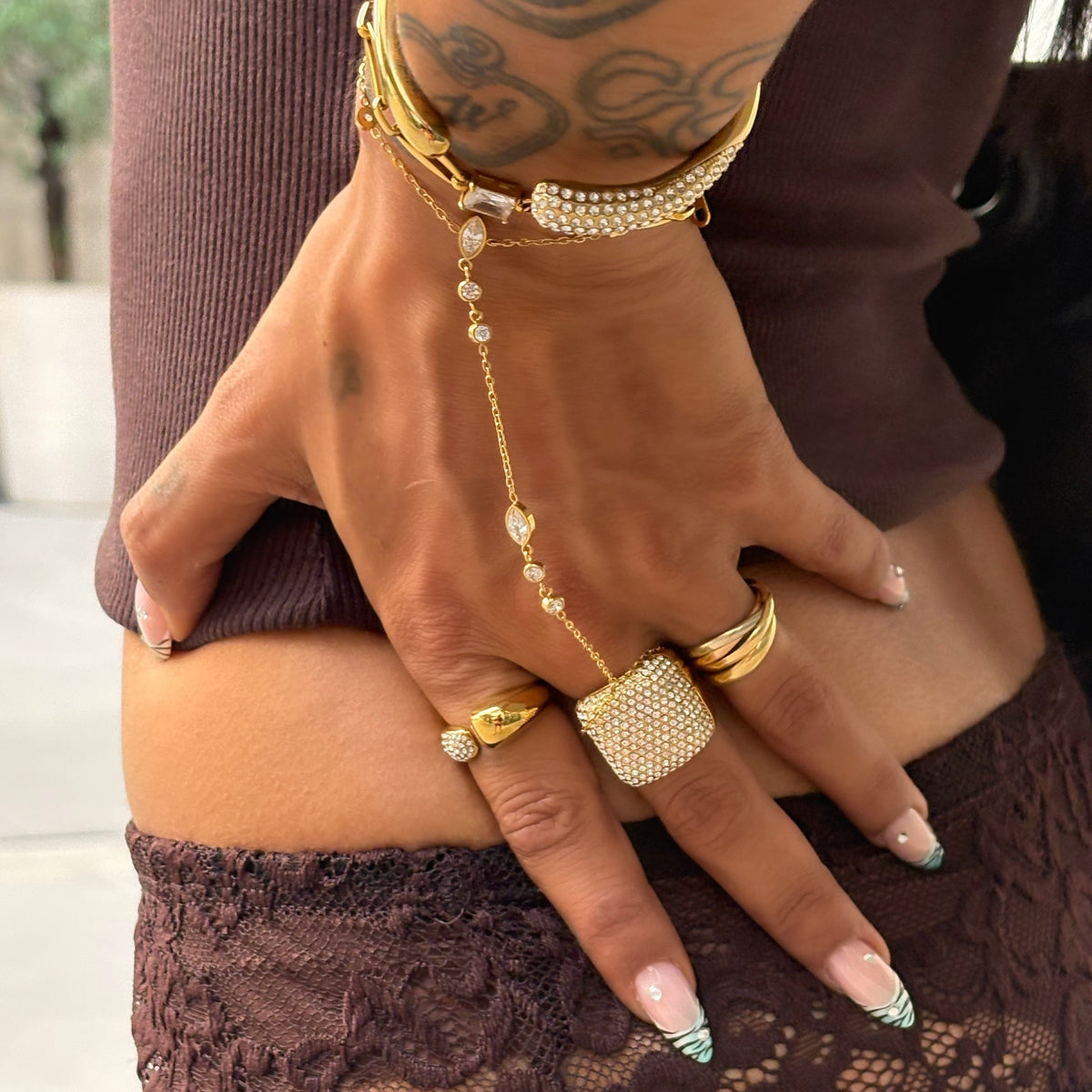 Bague Sixtine dorée à strass portée à la main avec une accumulation de bijoux Monalya