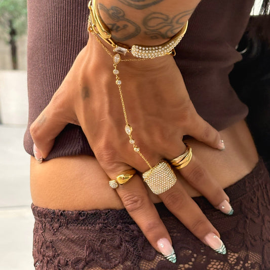 Bague Sixtine dorée à strass portée à la main avec une accumulation de bijoux Monalya