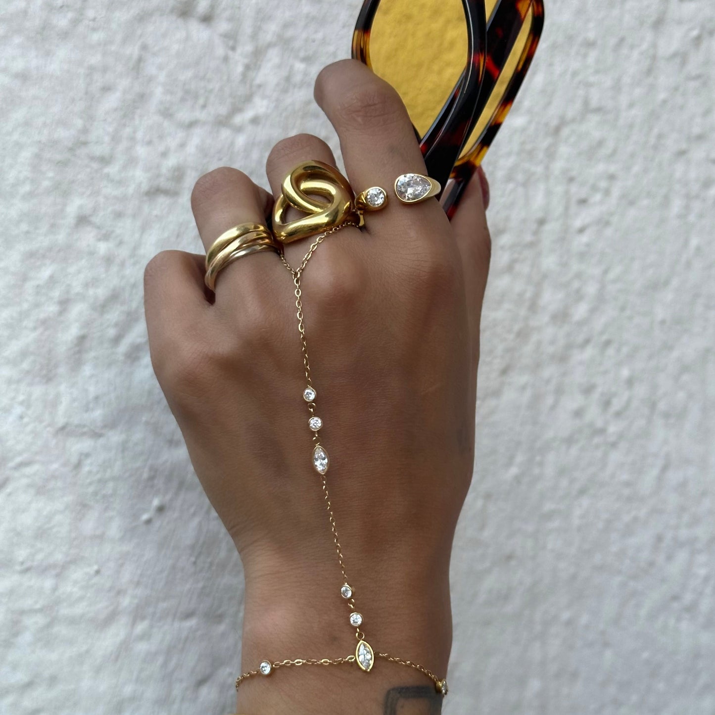 Bague Vanina en acier inoxydable doré avec deux zircons sertis de tailles différentes portée sur la main .