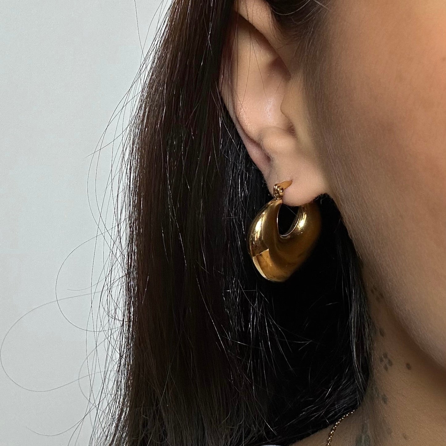 Boucles d’oreilles Aluna dorées en acier inoxydable portées – créoles épaisses et lisses – Monalya