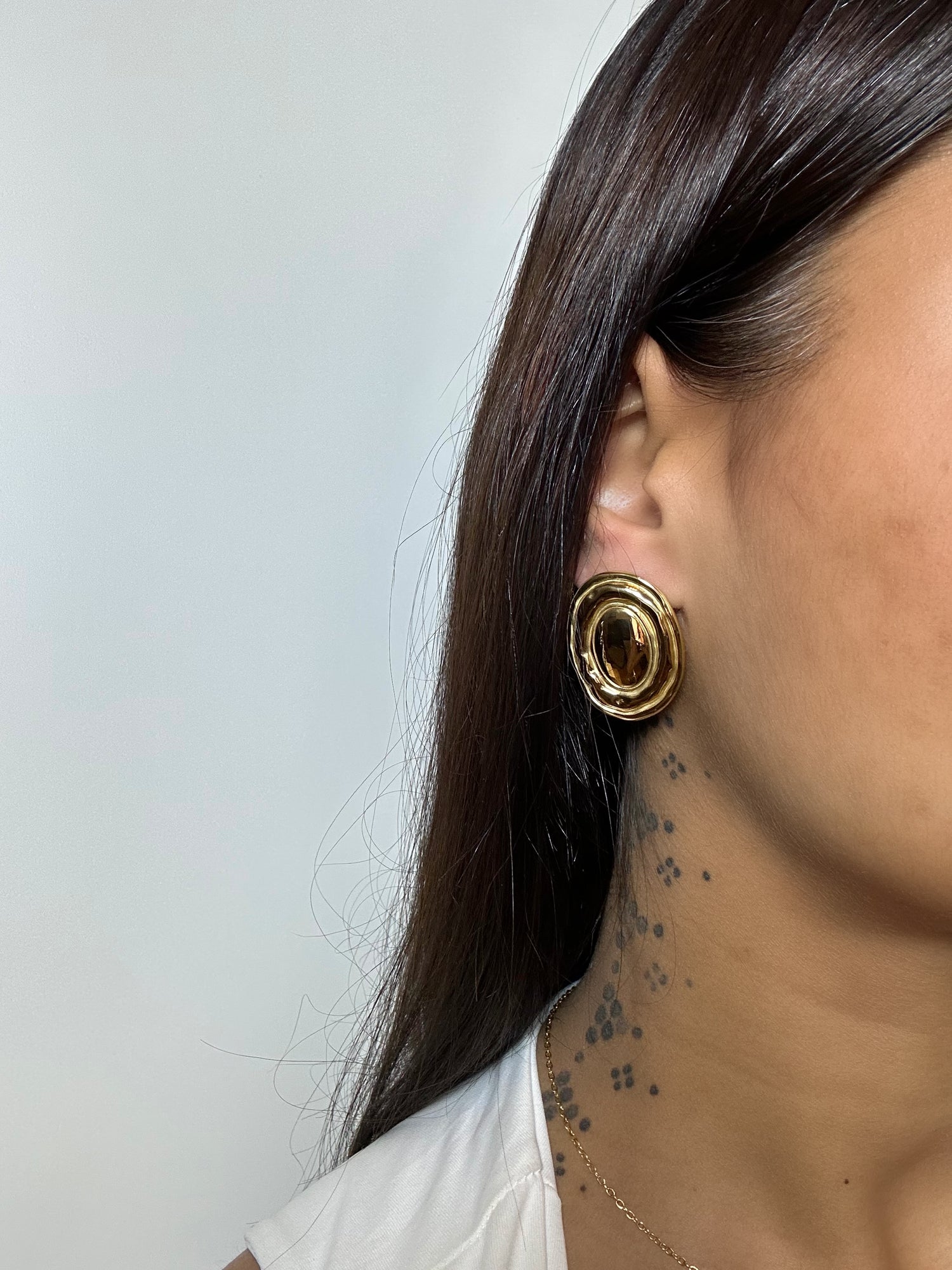 Boucles d’oreilles Freya dorées en acier inoxydable portées – design ovale texturé – Monalya 