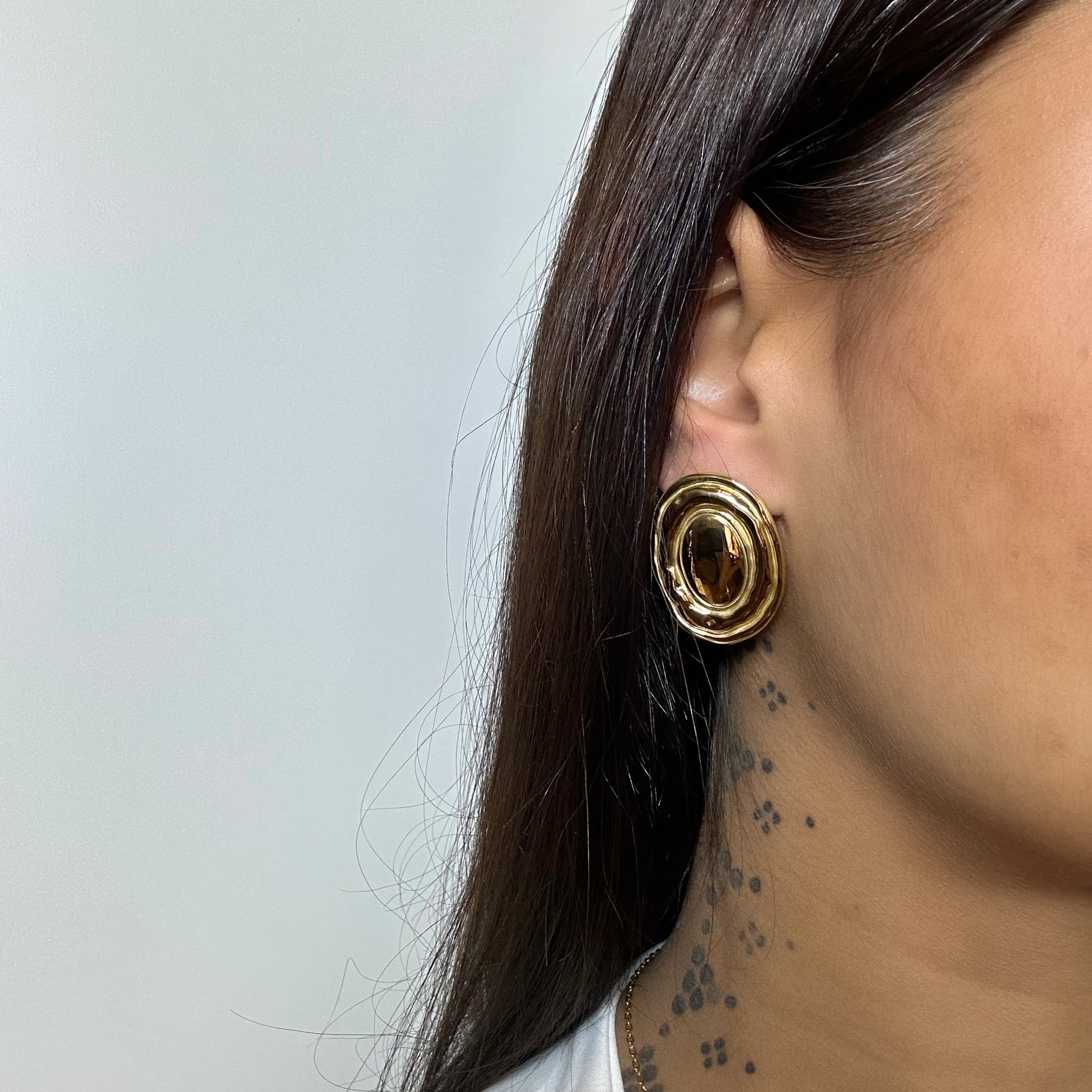 Boucles d’oreilles Freya dorées en acier inoxydable portées – design ovale texturé – Monalya 