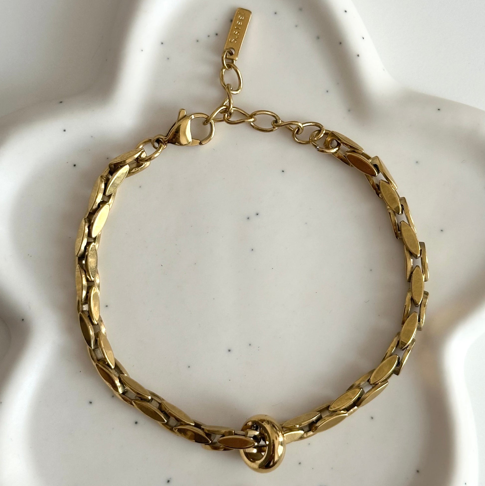 Bracelet Imany doré en acier inoxydable finition PVD or 18K présenté à plat sur un support blanc.