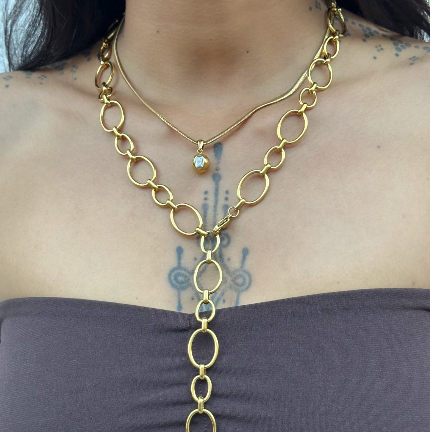 Collier Cielle en acier inoxydable doré avec pendentif boule et zircon rectangulaire porté.