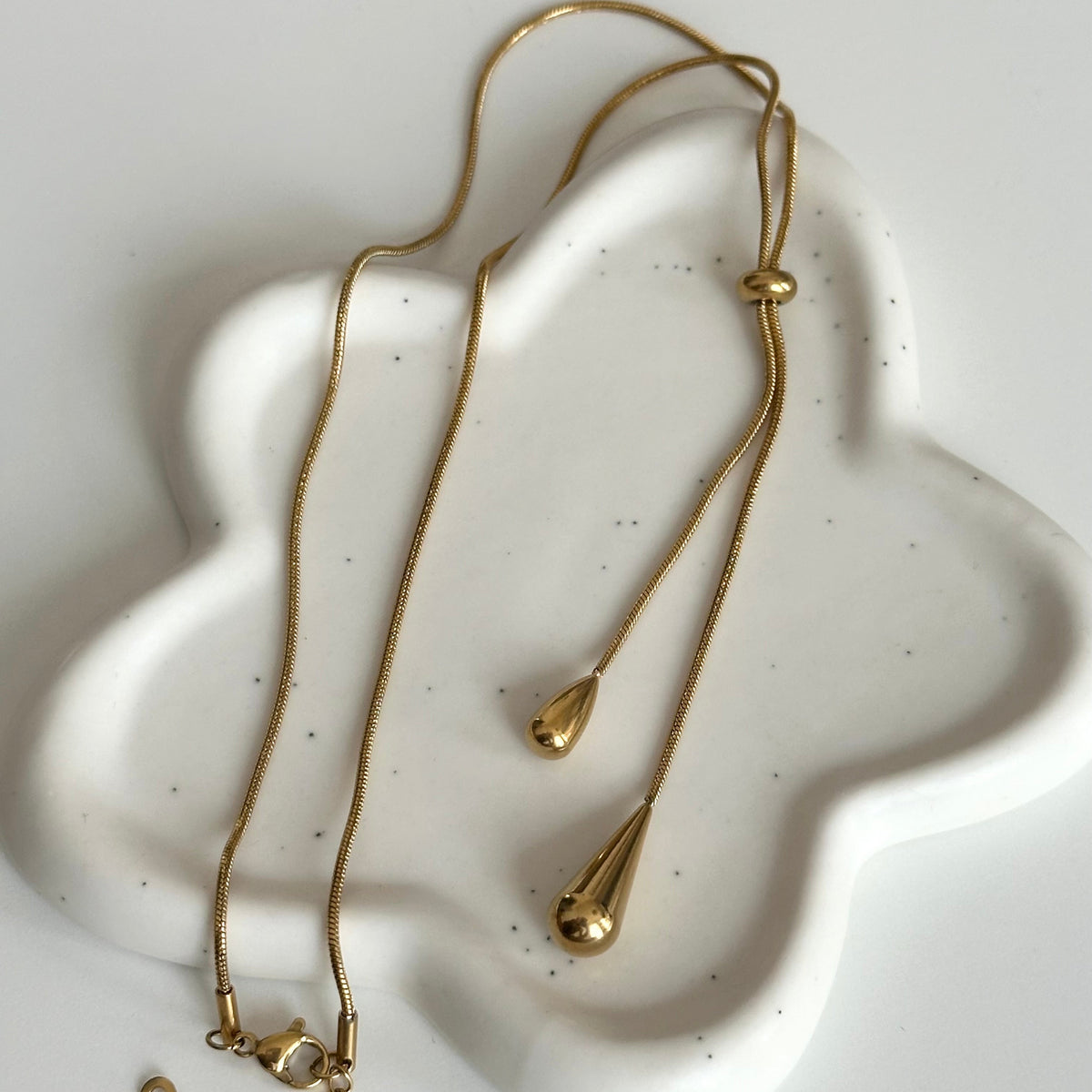 Vue complète du collier Jane doré en Y réglable grâce à sa boule centrale coulissante.