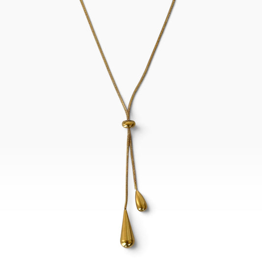 Collier Jane doré en Y avec boule coulissante et deux pendentifs en forme de goutte sur fond blanc.