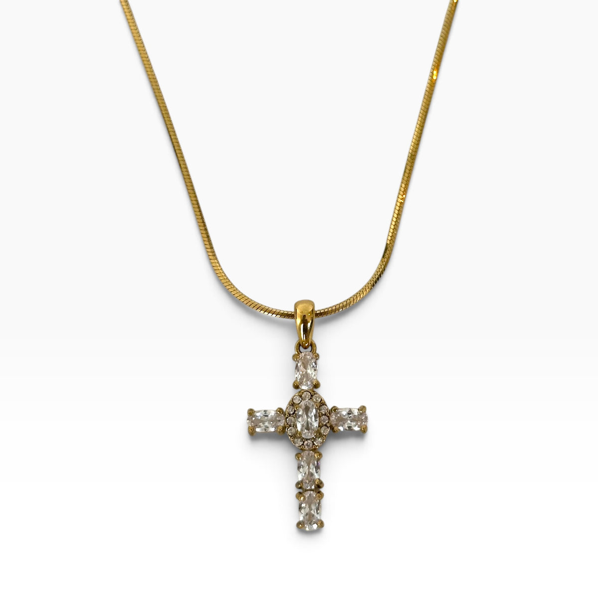 Collier Maria en acier inoxydable PVD or 18K avec pendentif croix serti de zircons sur fond blanc.