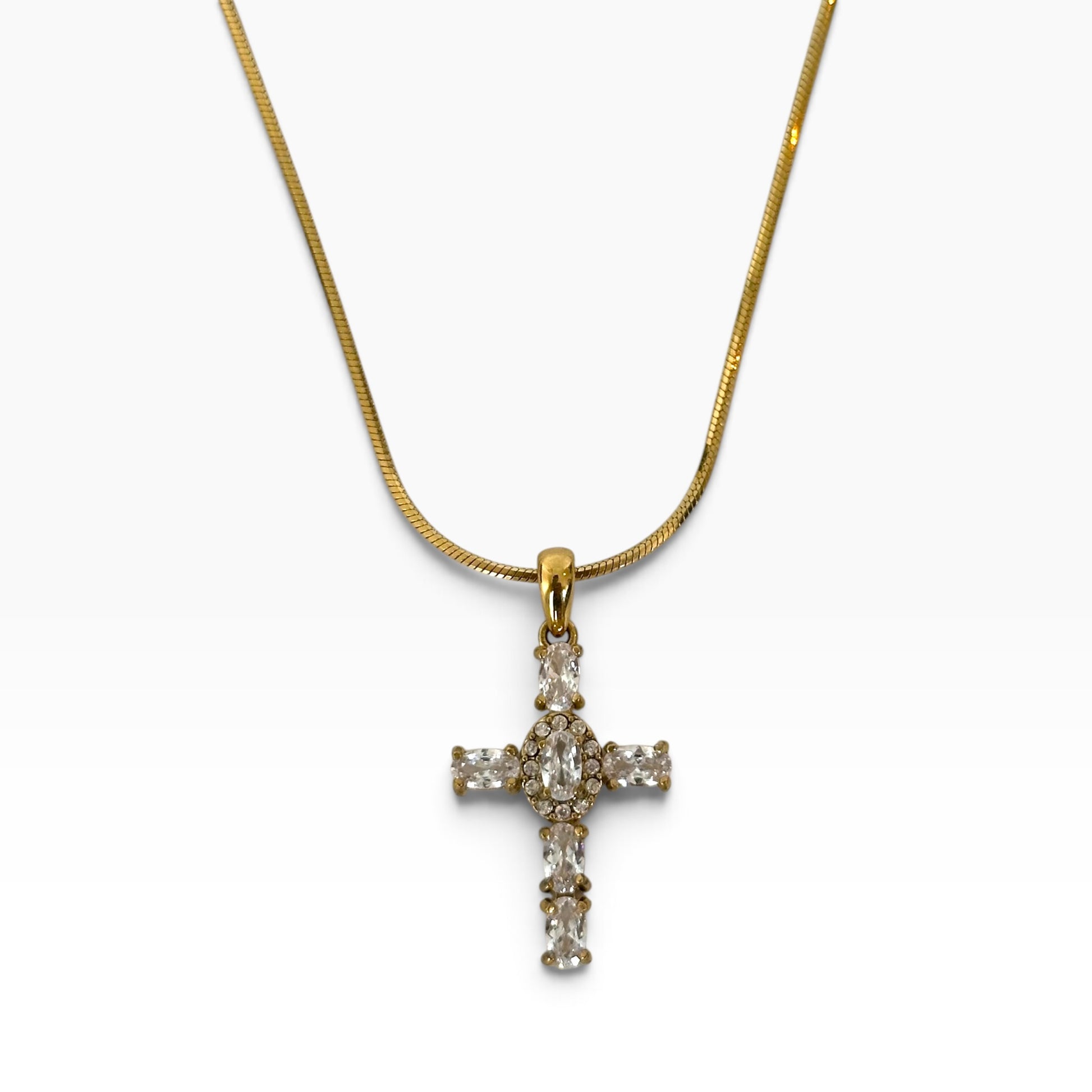 Collier Maria en acier inoxydable PVD or 18K avec pendentif croix serti de zircons sur fond blanc.