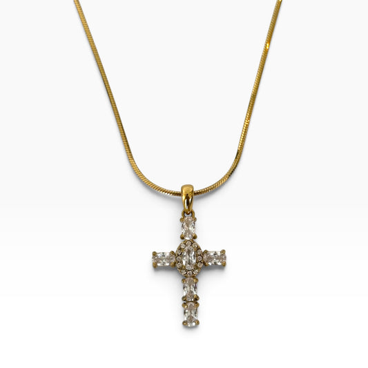 Collier Maria en acier inoxydable PVD or 18K avec pendentif croix serti de zircons sur fond blanc.