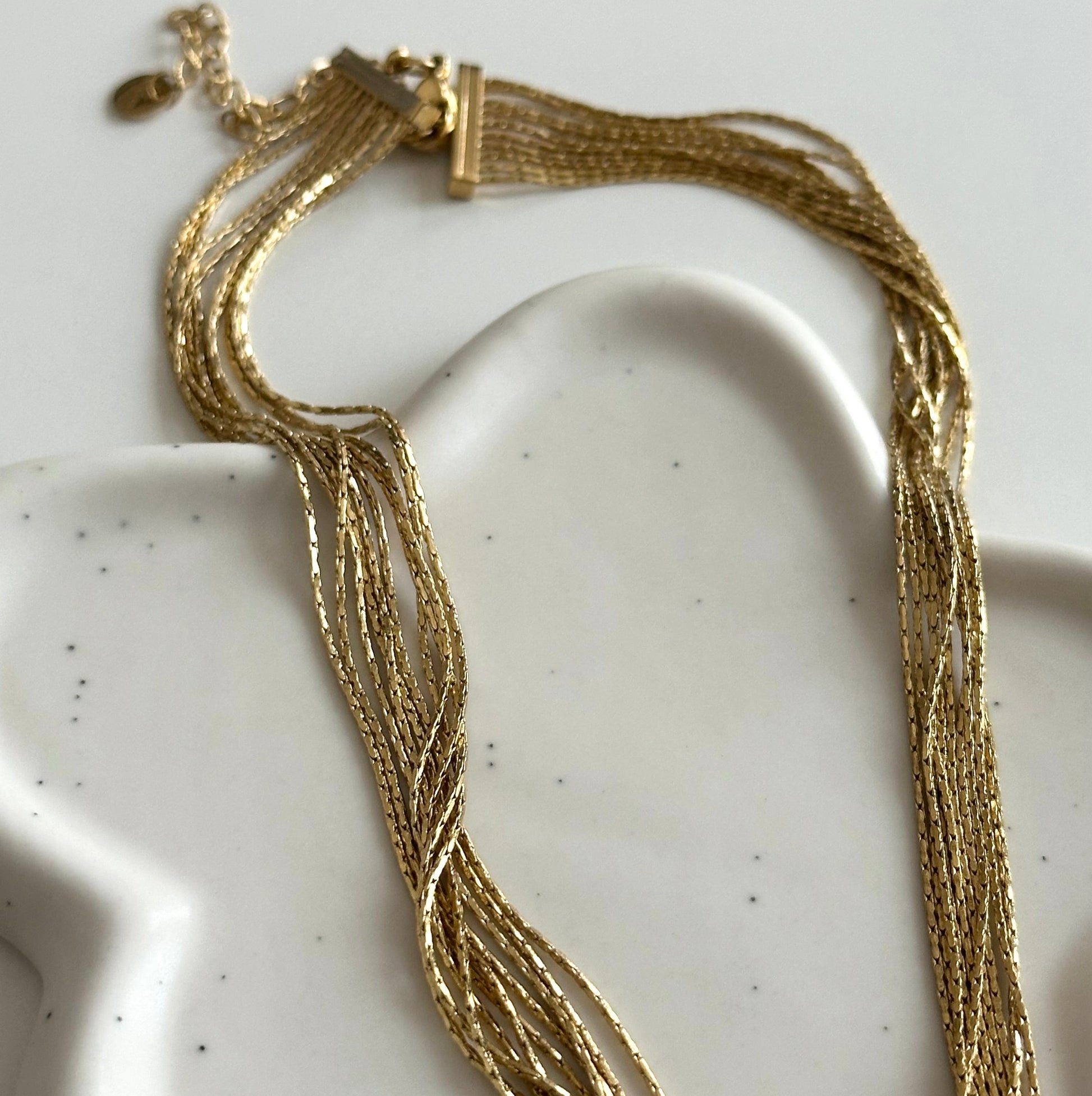 Collier Pao doré multirangs avec détail du fermoir et de la chaîne d’extension.